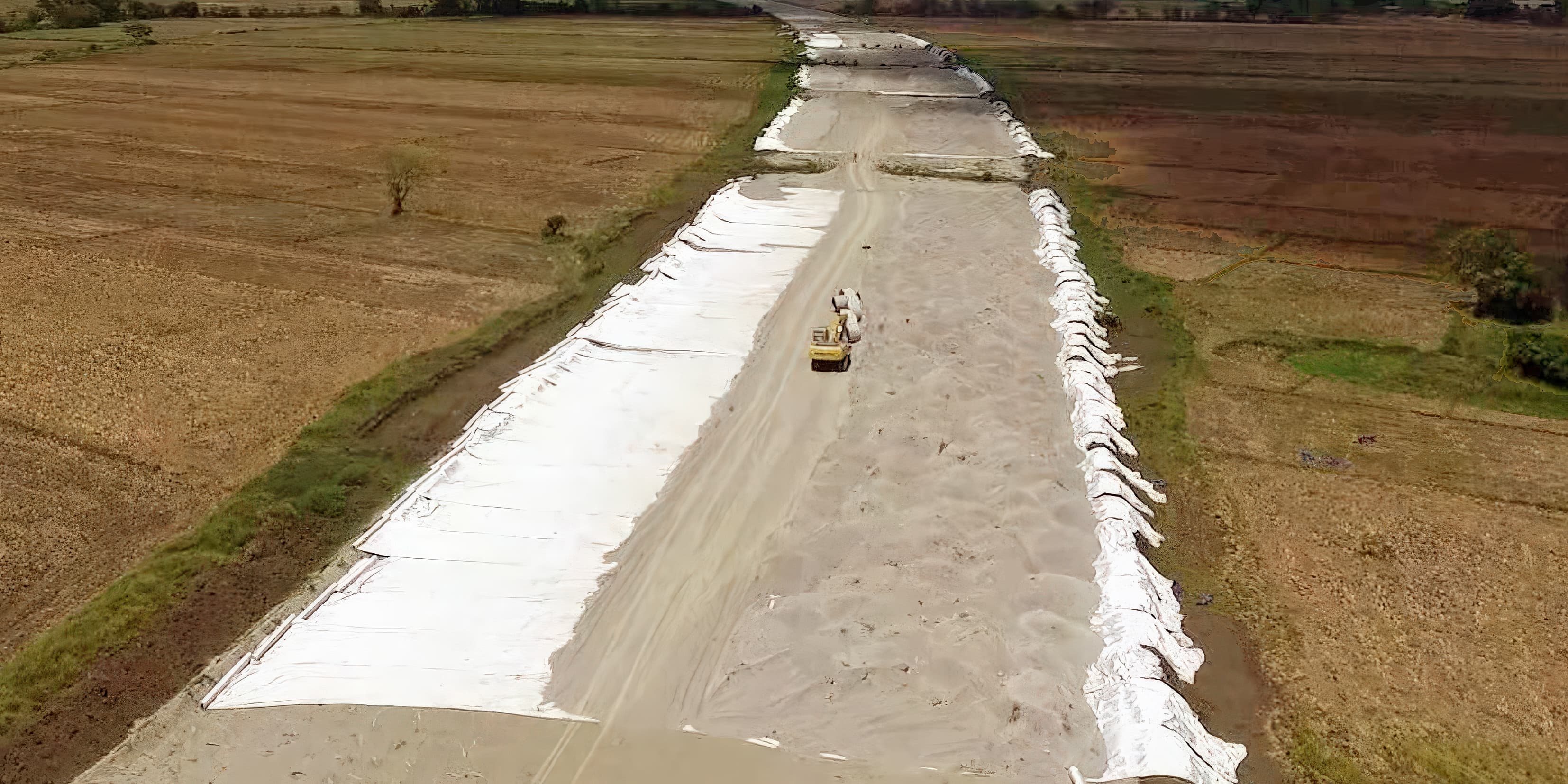 Installing MIRAFI PET600 basal geotextile reinforcement above sand blanket layer