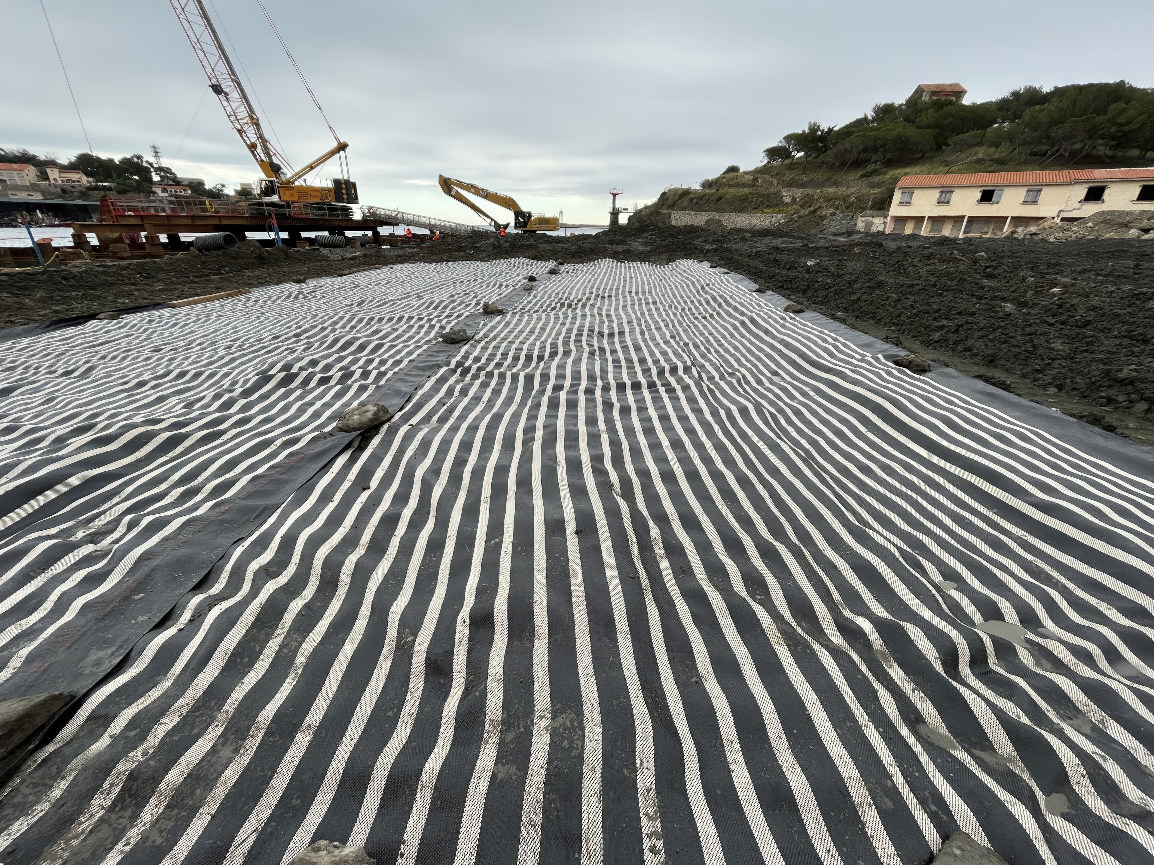 Maintaining trafficability over compressible soils during temporary port works