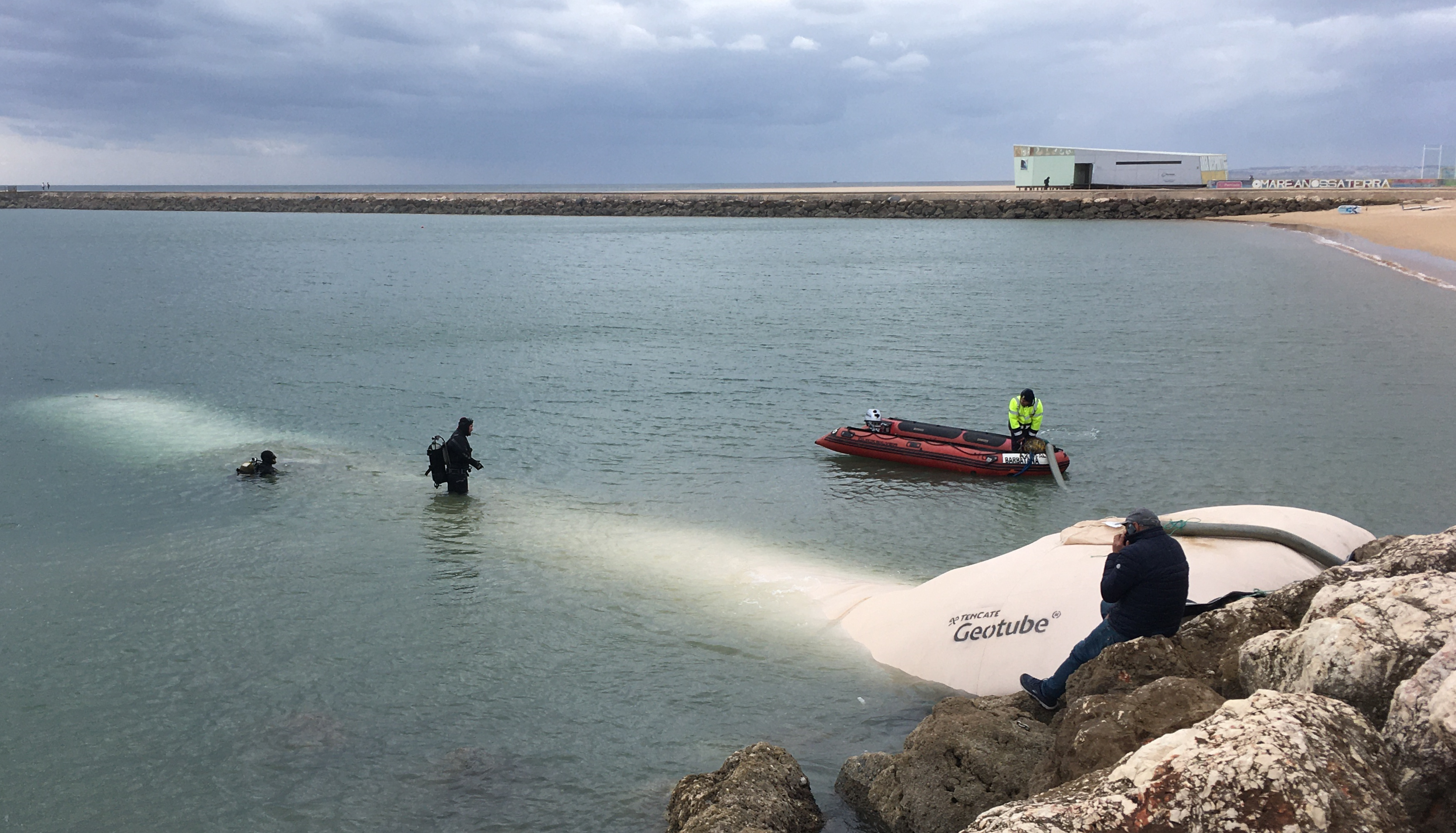 Installation of Solmax GEOTUBE systems at Marina of Portimão, with divers and marine equipment actively working in the water.