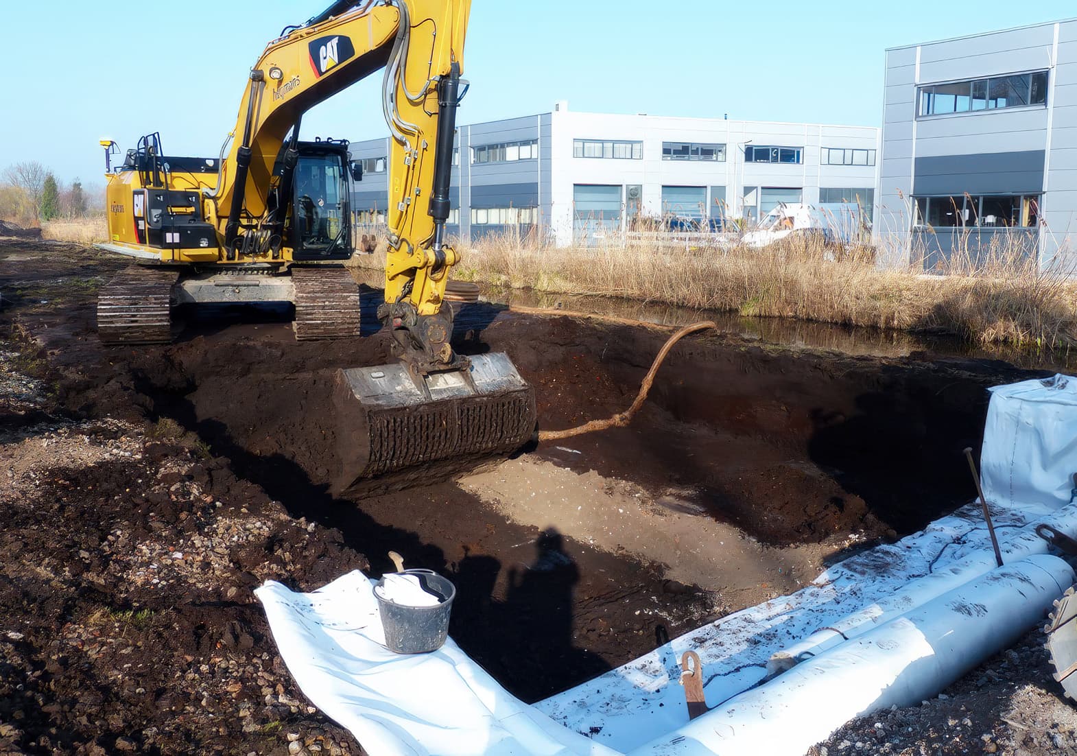 Granular embankment fill was placed and compacted in layers, followed by construction of the pavement and final grading to blend the embankment with surrounding ground.