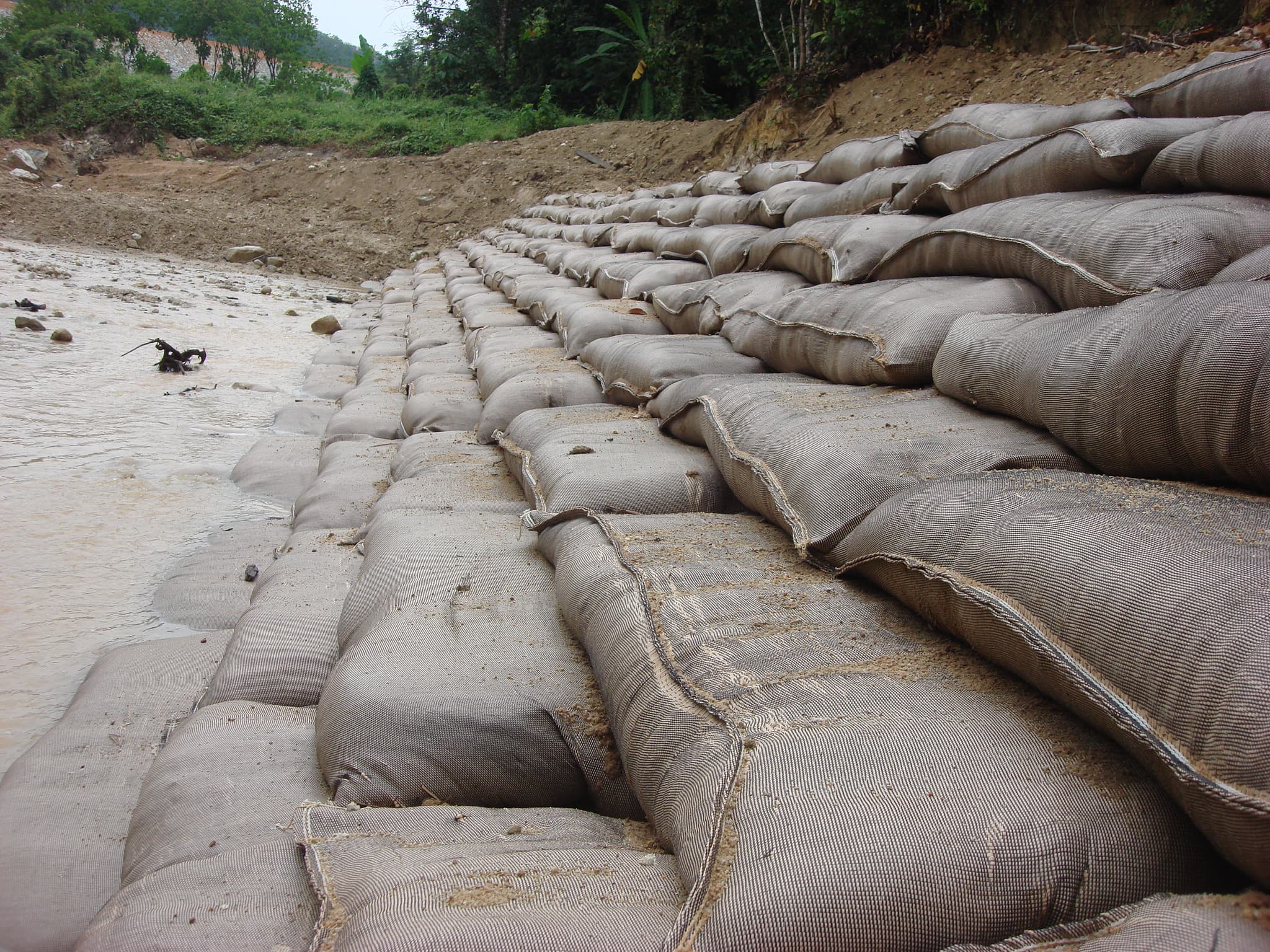 The housing developments near Sg. Choh in Selangor, Malaysia experiences high surface runoff, causing a significant increase in the river's water volume. This has led to severe erosion along approximately 200 m of the riverbank, posing a risk of collapse.