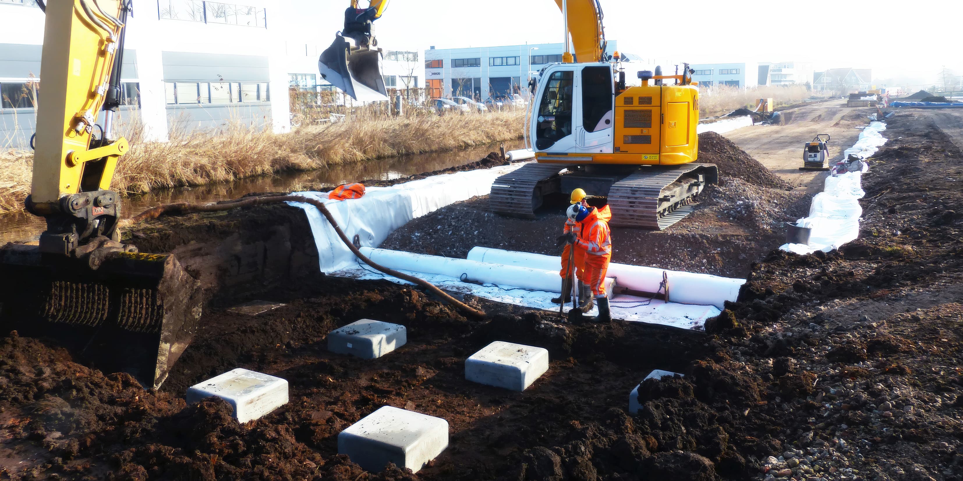 Piles and square pile caps were installed after excavating down to the groundwater level, forming the support system for the shallow embankment.