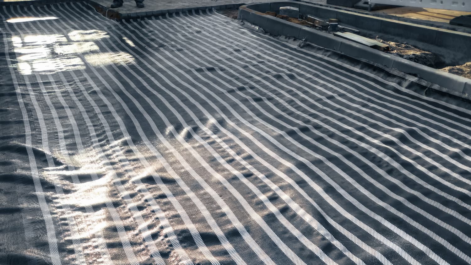 Installation of the MIRAFI HMi under challenging conditions, enhancing the base layer of the Kaufland parking lot