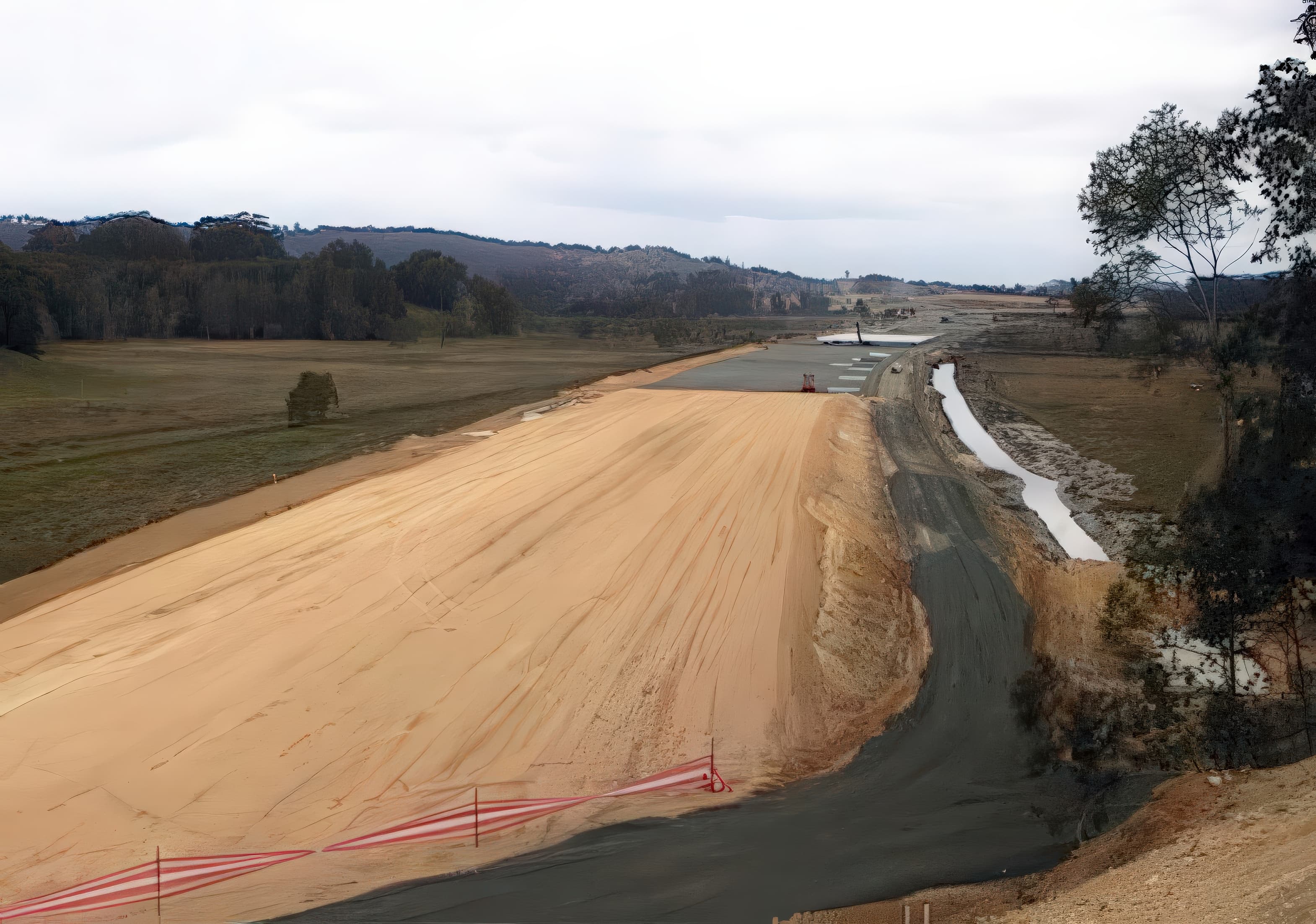 A separator geotextile was placed over the undisturbed grass surface, overlapped 0.5 m, and covered with a 0.5 m clayey bridging layer to create a platform for installing the vertical drains.