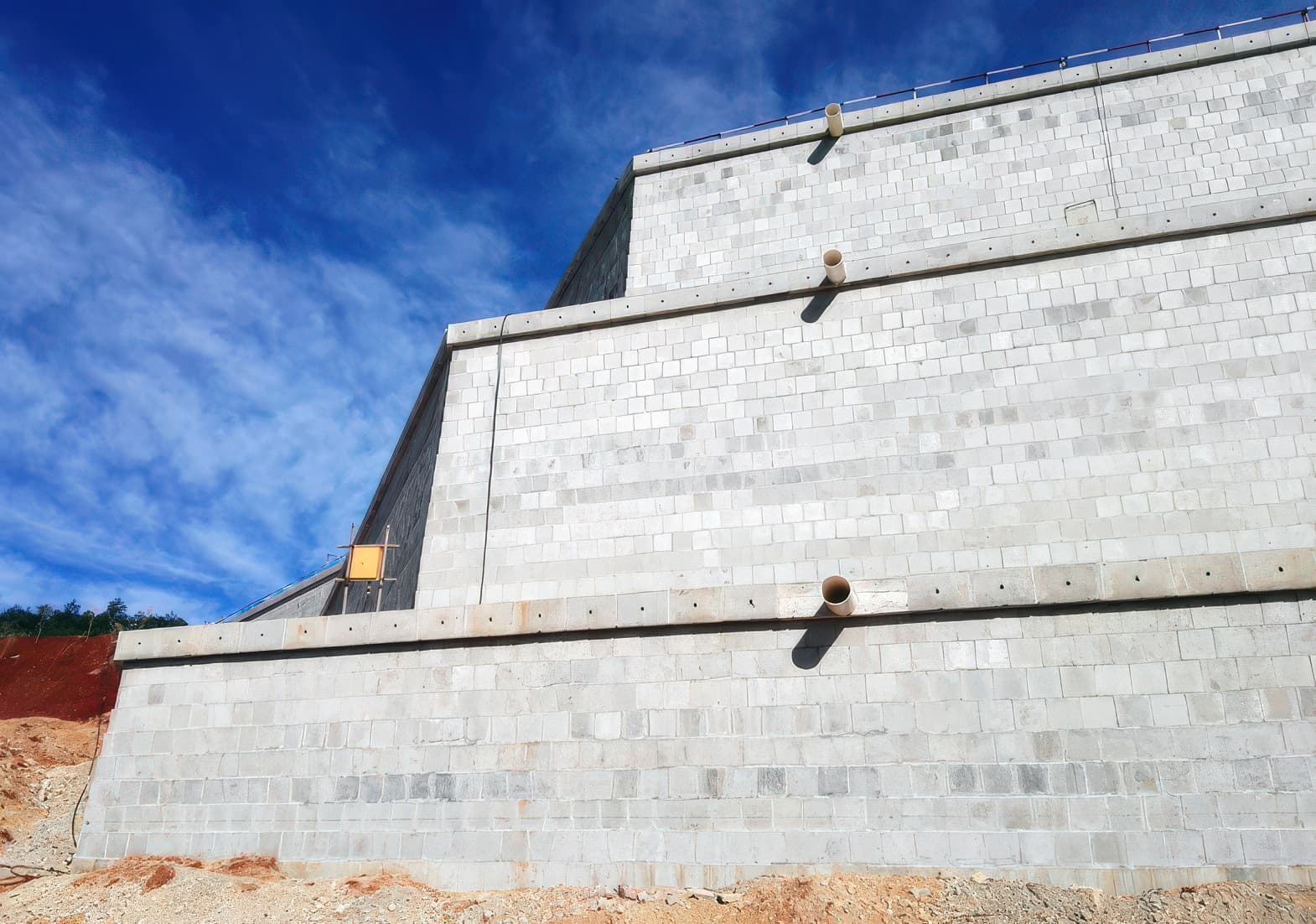 Reinforced segmental block walls showing drainage pipe exits