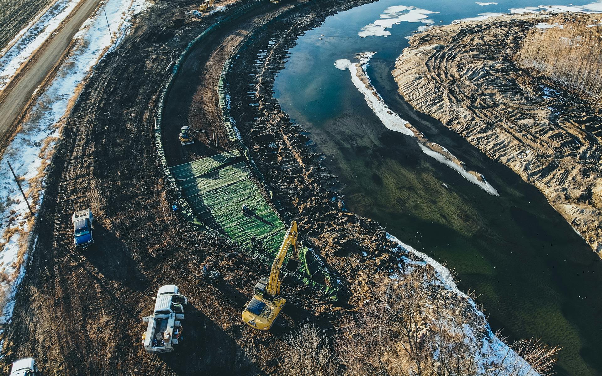 Excavation on a riverbank, in a snow covered terrain