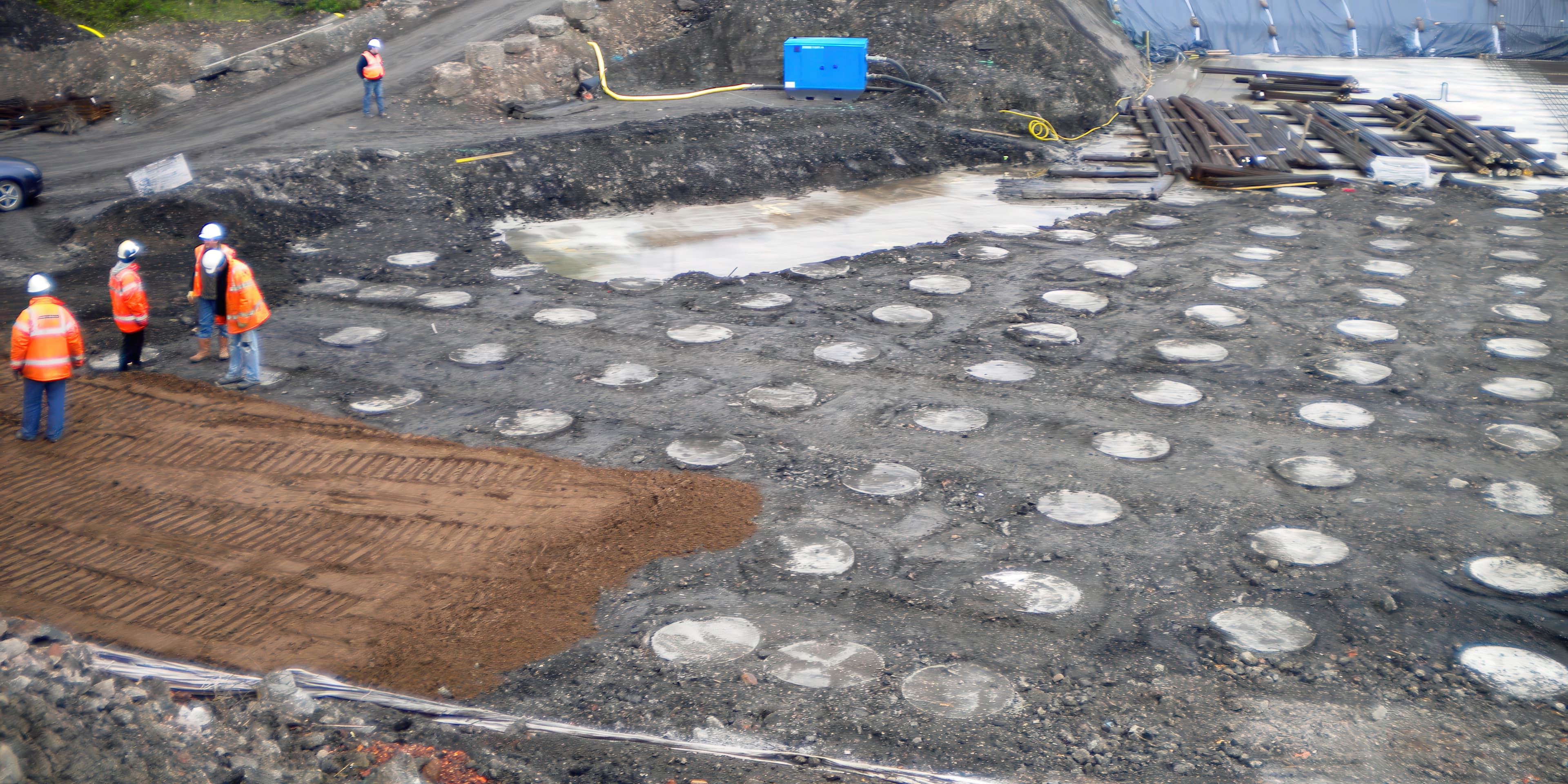 Prefabricated vertical drains were installed on a 2 m grid through the base drainage layer to depths up to 35 m, enabling rapid consolidation so embankment construction could continue within the project’s tight schedule.